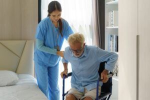 Nurse helping man get off a chair